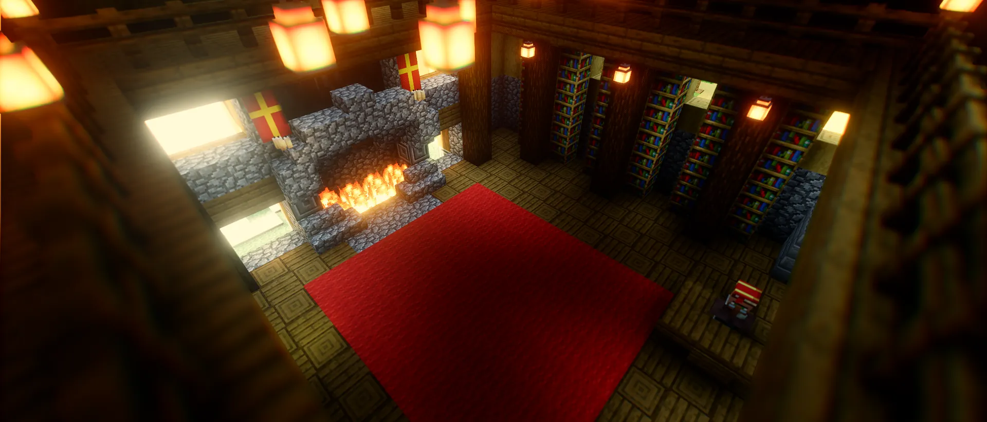 A timber hall seen from above: a red carpet, a cobblestone fireplace burning, and shelves of books under hanging lanterns.